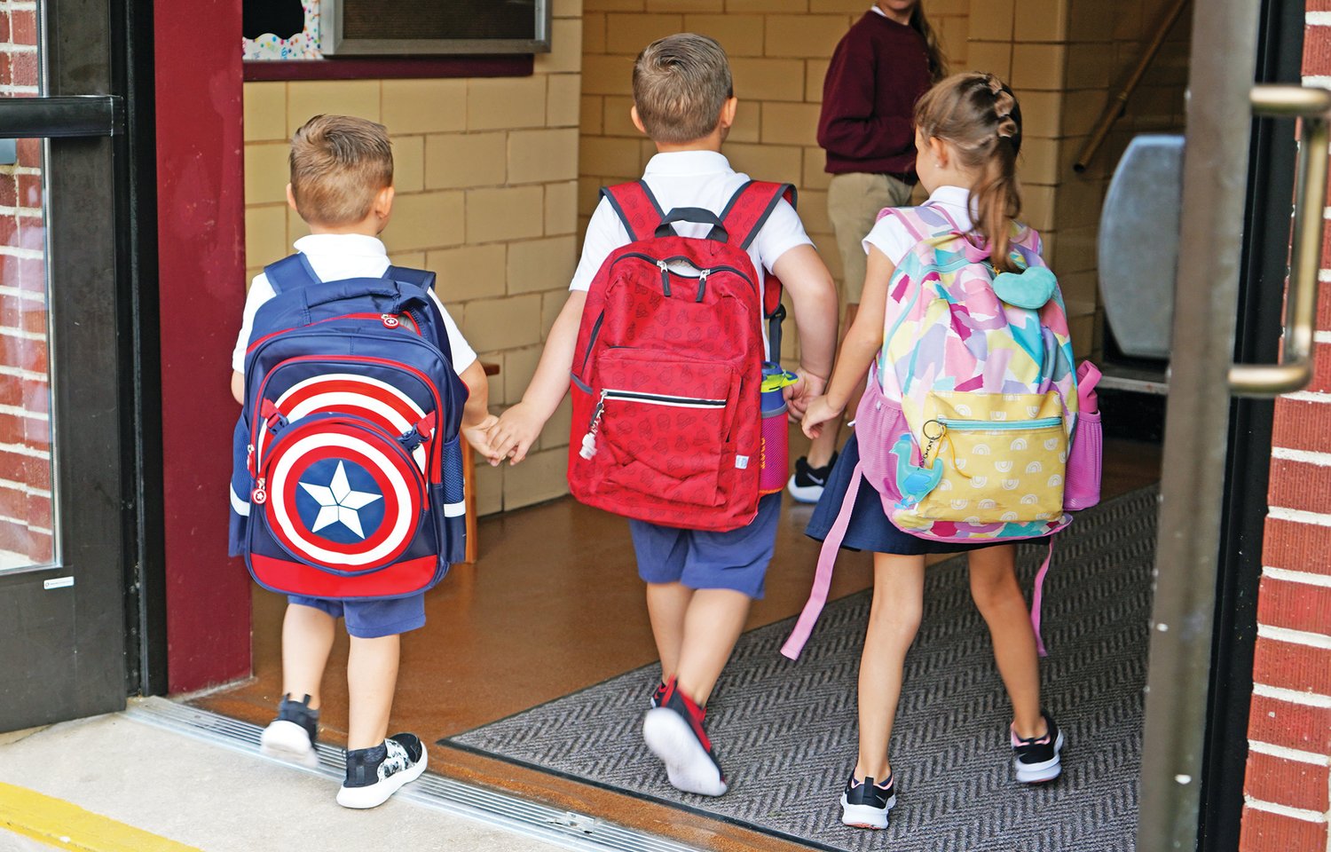 Three children enter St. George School in Hermann for the first time of their new school year on Aug. 19.